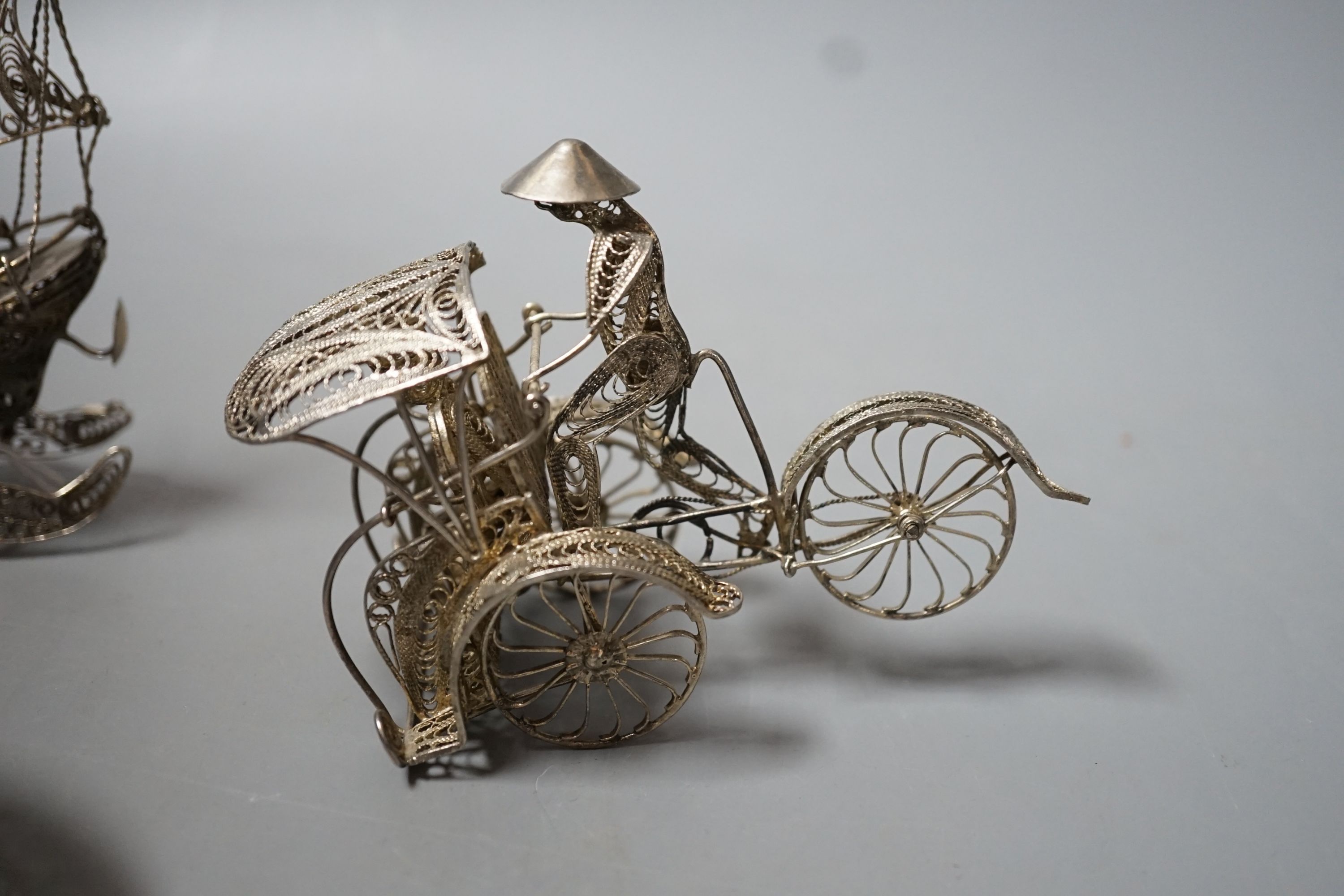 A Chinese filigree white metal model of a ship, length 19cm, a similar model of a rickshaw with driver and passenger and a similar oval box and cover